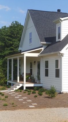 a white house with a porch and steps leading up to it