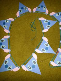 a group of blue and pink triangle shaped items with eyes on them sitting on the ground