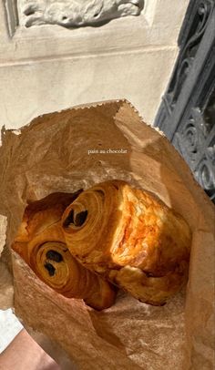 a croissant in a brown paper bag