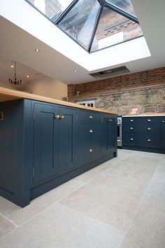 a kitchen with blue cabinets and a skylight