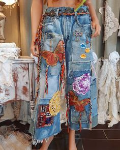 a woman standing in front of a rack with many different items hanging on it's sides