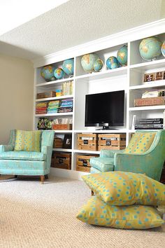 a living room filled with furniture and a flat screen tv mounted on a wall next to a window