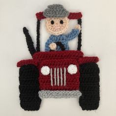 a crocheted red truck with a man on it