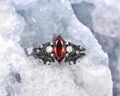 a close up of a ring on top of some ice with diamonds and garnetia