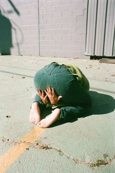 a man laying on the ground with his head in his hands