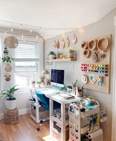 a home office with lots of crafting supplies on the desk and shelves above it