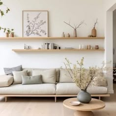 a living room filled with lots of furniture next to a wall mounted shelf above a white couch