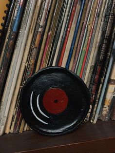 a record player sitting on top of a wooden shelf filled with vinyl records and cds