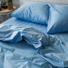 a bed with blue sheets and pillows on it