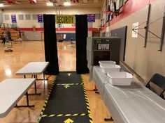 Entrance rugs sere taped down with caution tape/ tables covered with silver table cloths, large box with duct tape “flaps” to slide boxes through (Allowed us to make sure they brought water bottles and added  other supplies as it passed through the “scanner”.). Black curtains over pvc pipe frame for walk-through scanner. Airport Party Decorations, Airport Theme Preschool, Airport Classroom Transformation, Airport Birthday Party, Airport Decorations Travel Themes, Airport Theme Classroom, Airport Classroom Theme