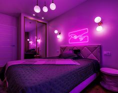 a bedroom with purple lighting and a large bed