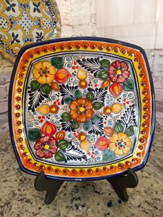 two colorful plates sitting on top of a table