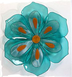 a blue glass flower with orange centers on a white background