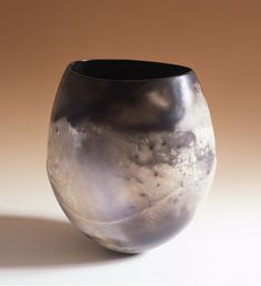 a black vase sitting on top of a white table