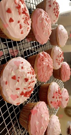 cupcakes with pink frosting and sprinkles on cooling rack in kitchen