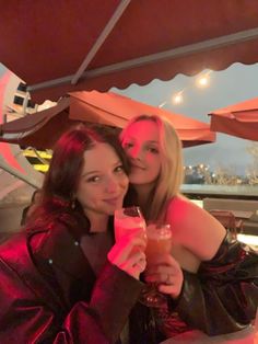 two women sitting at a table with drinks