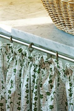 a close up of a curtain in front of a basket on a window sill