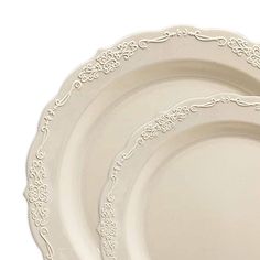 three white dinner plates with ornate designs on the rims, set against a white background