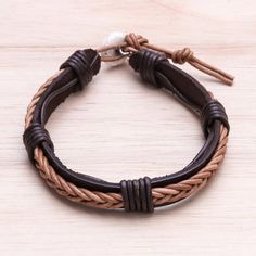 Circling the wrist hand-braided leather cord in black decorates a dark brown wristband. Thailand's Chaloemphon presents this bracelet crafted by local artisans. An adjustable howlite button clasp completes this accessory. Adjustable Brown Leather Bracelet Gift, Adjustable Vintage Brown Leather Bracelet As Gift, Adjustable Vintage Brown Leather Bracelet Gift, Adjustable Vintage Brown Leather Bracelet, Adjustable Brown Leather Bracelet With Black Band, Brown Leather Bracelet With Black Band, Handmade Brown Leather Friendship Bracelet, Brown Waxed Cord Bracelet, Brown Handmade Leather Bracelet With Waxed Cord