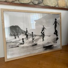 a framed photo of people surfing on the water