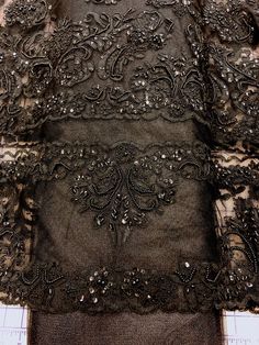 Priced per yard. Black beaded border lace with three borders on each selvage and many motifs. 52-inches wide. Perfect for decorating tutus and other costumes. Smallest length sold online: one yard. Luxury Fitted Lace With Intricate Embroidery, Luxury Lace Dress With Intricate Embroidery, Luxury Lace Trim Dress For Costume Party, Luxury Lace Trim Gown For Parties, Luxury Dresses With Lace Trim For Costume Party, Luxury Evening Lace Dress With Lace Trim, Luxury Evening Skirt With Lace Trim, Luxury Black Bottoms With Contrast Lace, Luxury Festive Lace With Intricate Embroidery