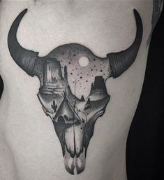 a bull skull tattoo on the back of a man