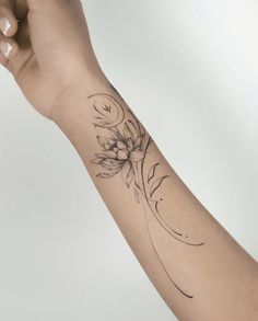 a woman's arm with a flower tattoo on it