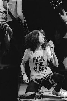 a black and white photo of a woman on stage with a microphone in her hand