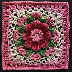 a crocheted square with pink flowers on it