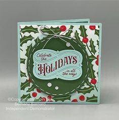 a christmas card with holly wreaths on it