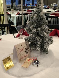 a small christmas tree sitting on top of a table next to a card and other decorations