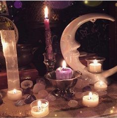 candles are lit in front of a crescent and other items on a table with an ornament