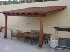 a patio covered with wooden furniture and an awning over the dining room table area