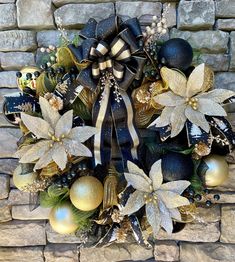 a wreath with poinsettis and christmas balls on it is hanging on a brick wall