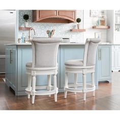 two white stools sitting in front of a kitchen counter