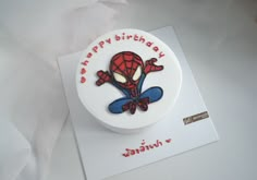 a spiderman birthday cake on top of a white card with the words happy birthday written in it