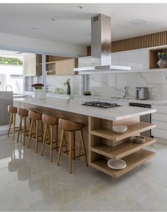 a kitchen island with stools in front of it and an oven on the other side