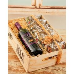 a wine bottle and chocolates in a wooden box