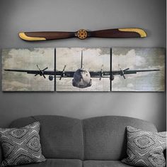 an airplane is flying in the sky on a wall above a couch with two pillows