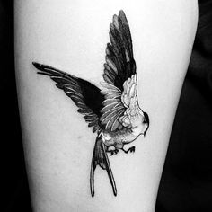 a small bird tattoo on the thigh