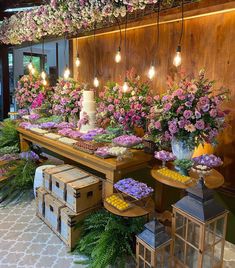 an arrangement of flowers on display in a flower shop with wooden crates and lanterns hanging from the ceiling