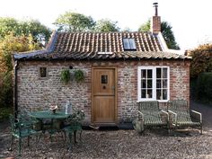 a small brick building with chairs and tables outside