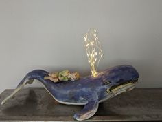 a blue whale with some lights on it's head and body is sitting on a metal tray