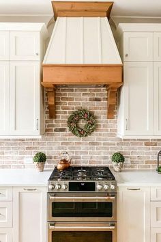 a stove top oven sitting inside of a kitchen next to white cabinets and counter tops