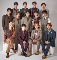 a group of young men sitting next to each other in front of a white background