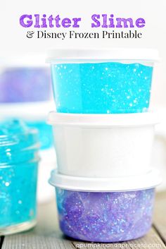 three plastic containers filled with blue and purple colored food sitting on top of a wooden table