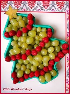 grapes and raspberries are arranged in the shape of a christmas tree on a plate