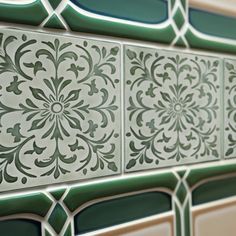 decorative tiles on the side of a wall with green and white designs inlays