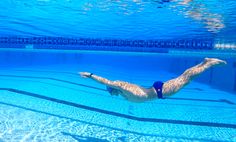 a man swimming underwater in a pool