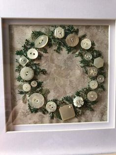 a wreath made out of buttons in a white frame